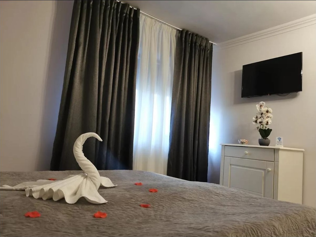 Pat pregătit cu prosoape aranjate și petale, lângă fereastră
