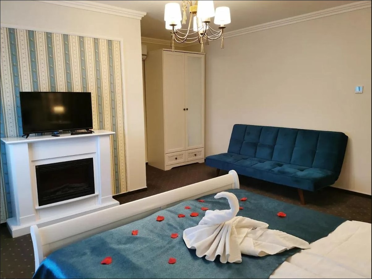 Living cu canapea albastră, șemineu decorativ și televizor