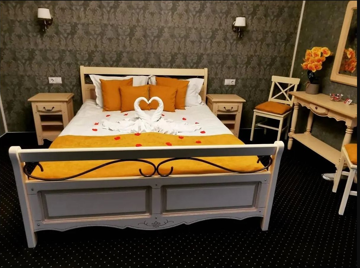 Cameră cu pat, birou și accente galbene